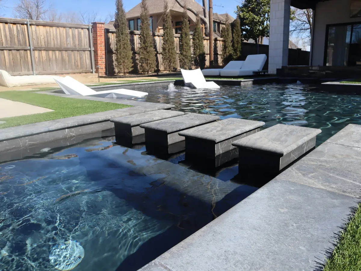 Dark bottom pool with concrete stepping pads