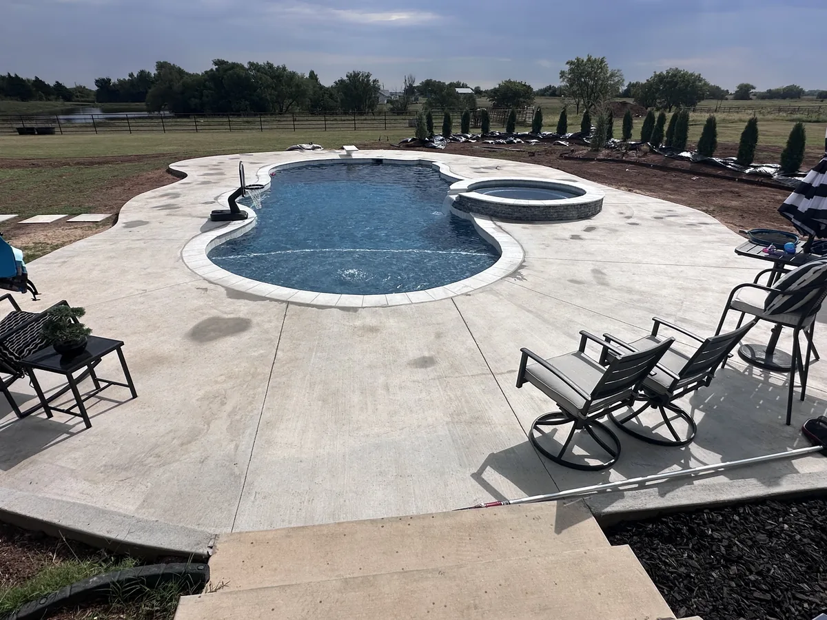 Freeform pool with lounge deck and hedge border