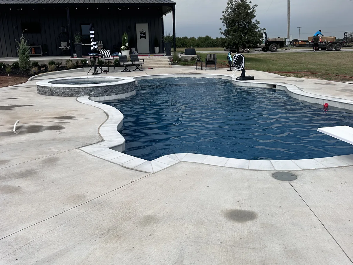 Freeform pool with wide concrete pool deck