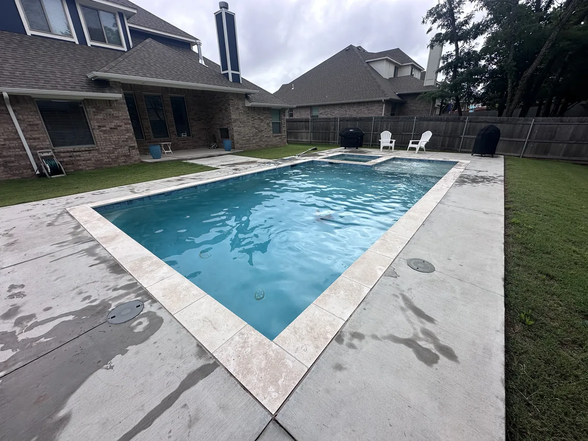 Geometric pool and deck behind a home