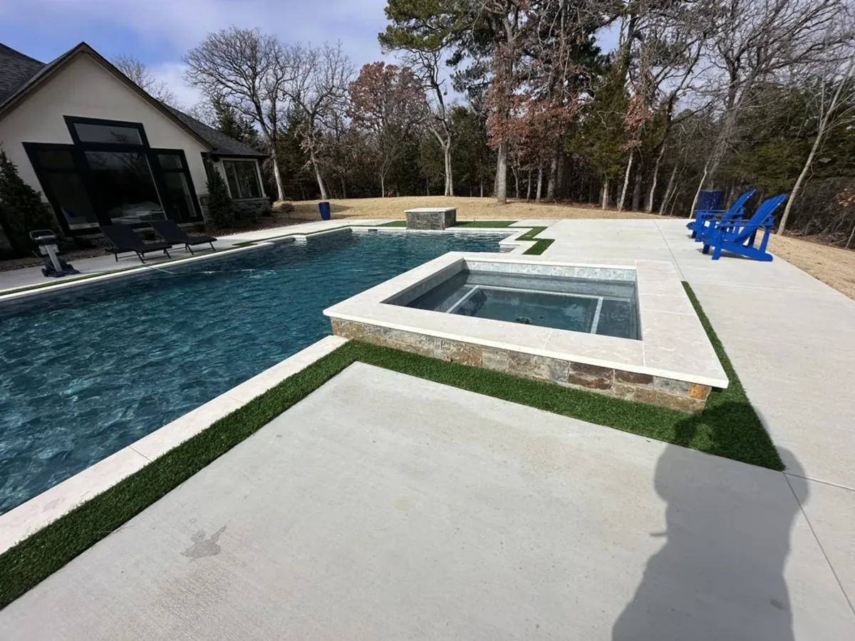 Geometric pool with stone veneer spa and turf deck