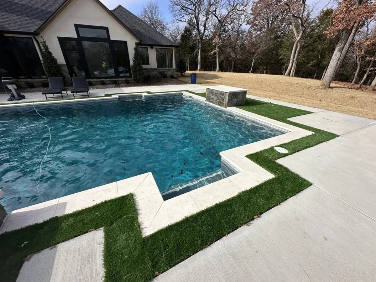 Geometric pool with turf inlay deck and raised spa