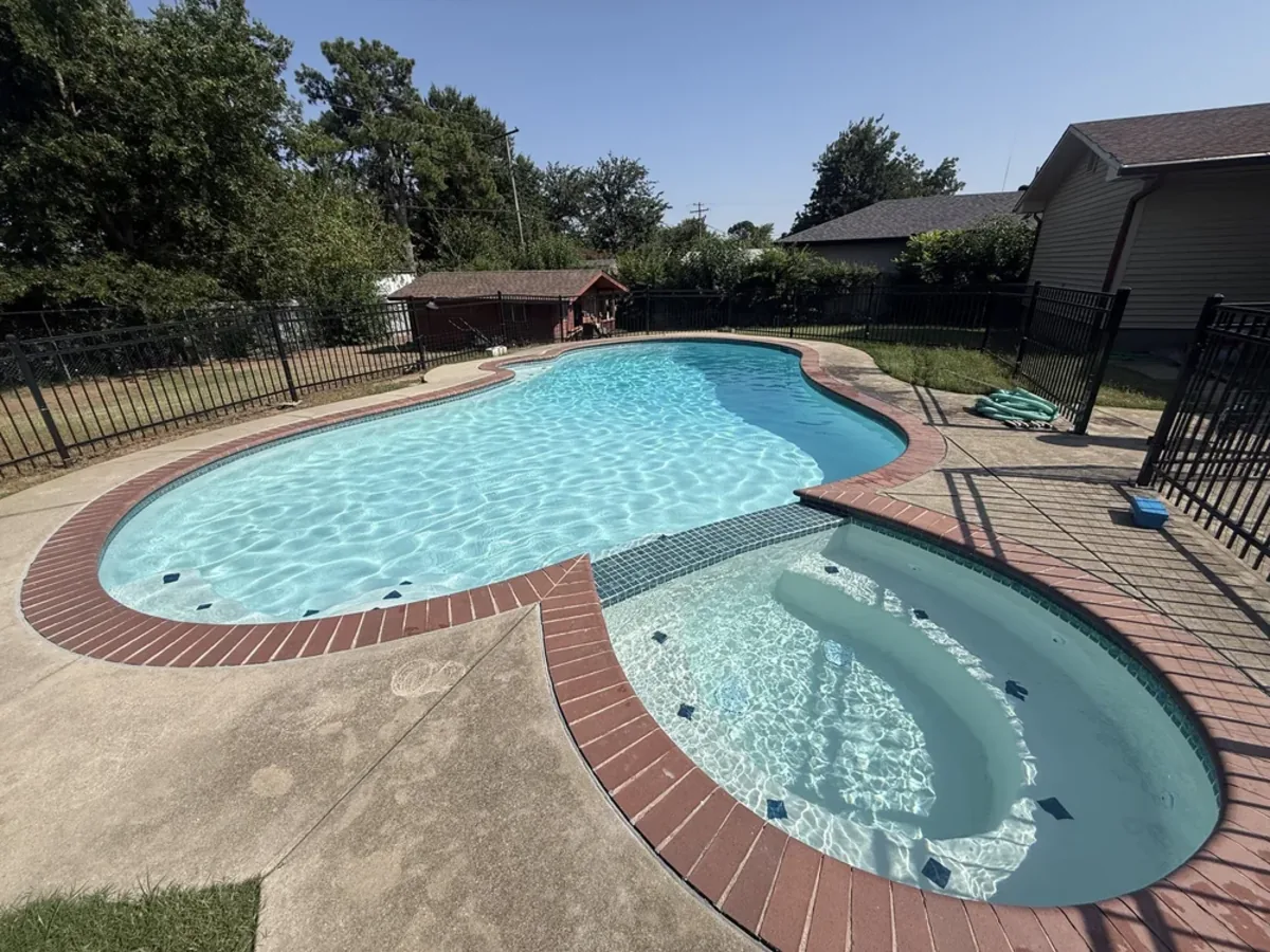 Kidney shaped pool with brick coping, spa and patio