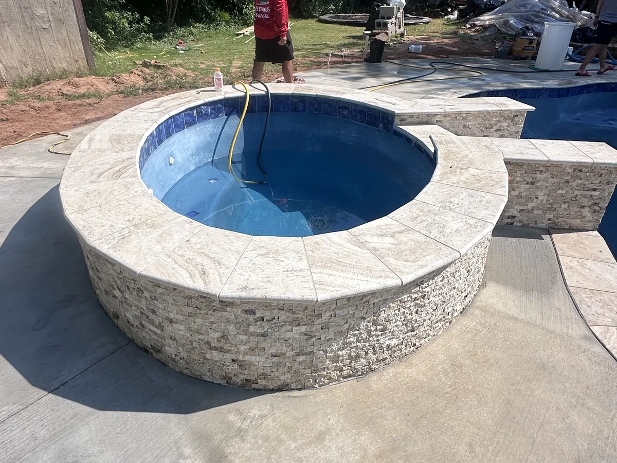 Raised spa with stacked stone wall and blue tile