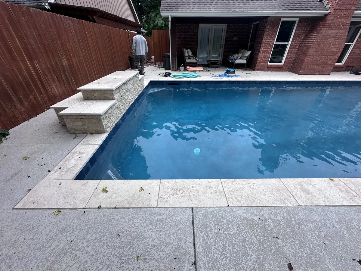 Rectangular pool with sun ledge and lounge chairs