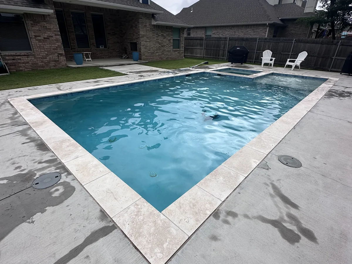 Rectangular pool with travertine deck, corner view
